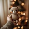 Hand holding a small handmade crochet bear plushie in soft yarn.